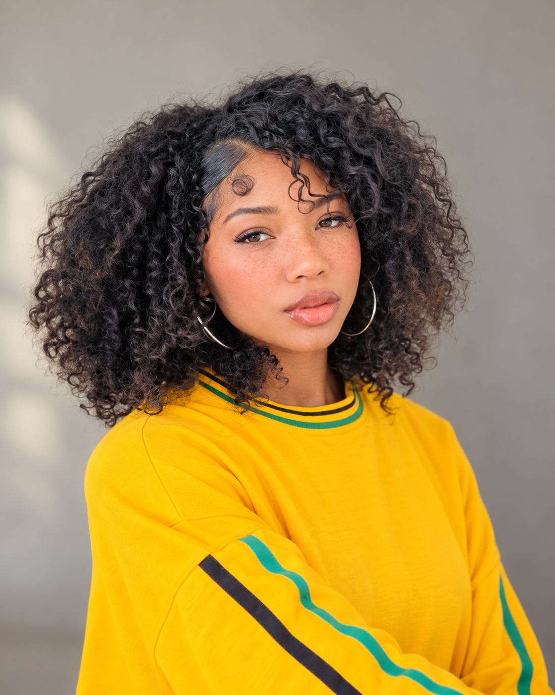 Edited personal portrait of Keyonna with curly hair in her yellow shirt