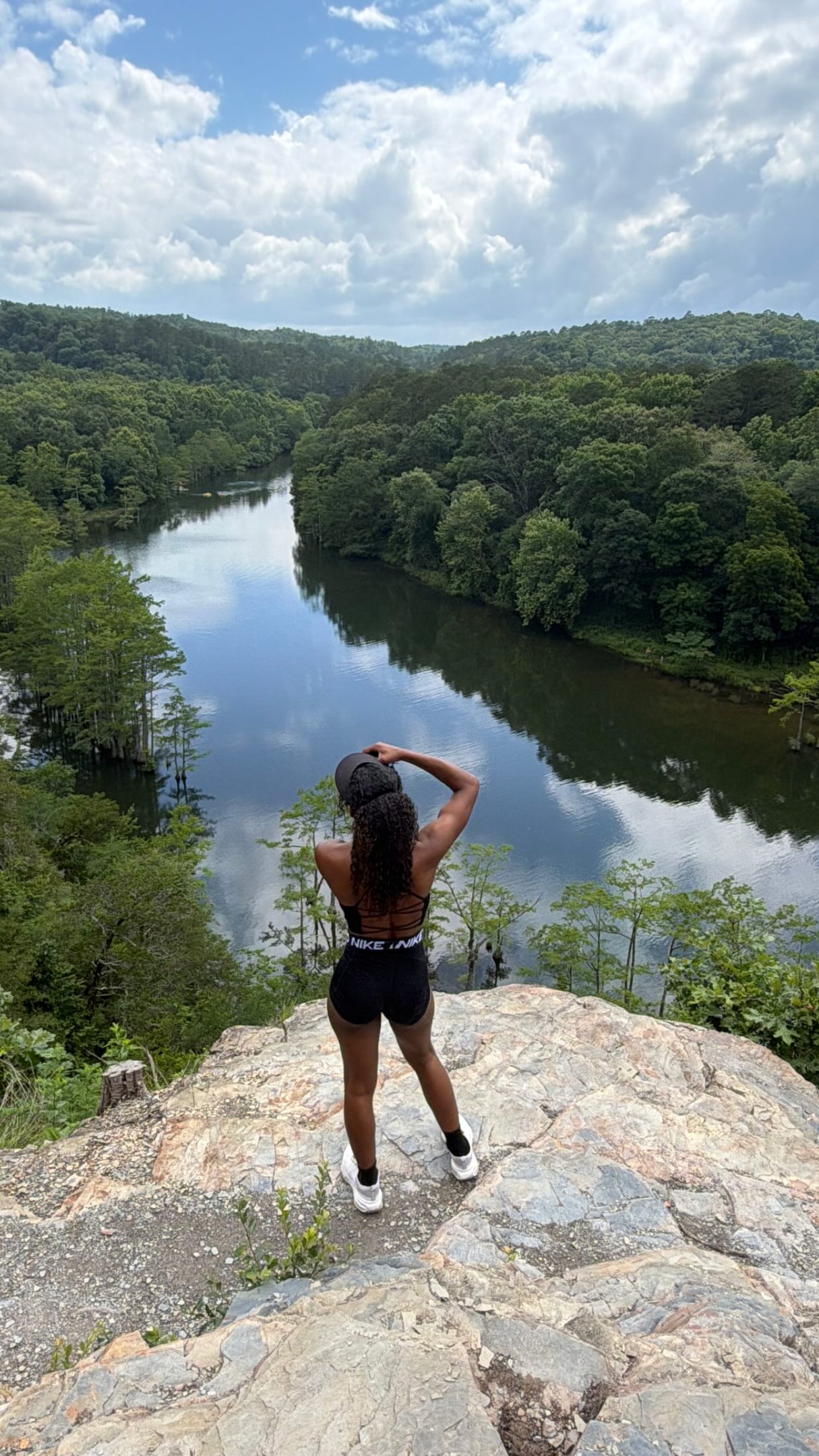 Keyonna overlooking a river and forest from a rock viewpoint