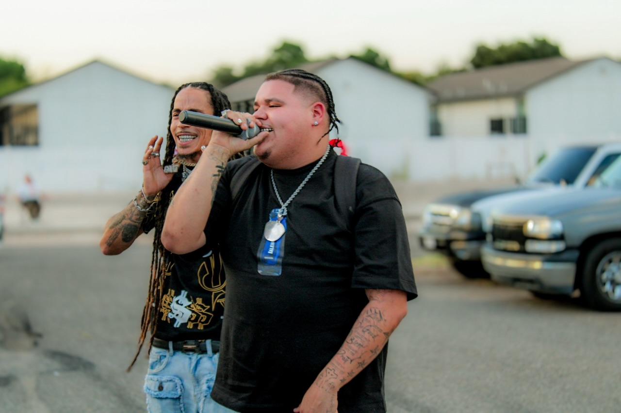 Two performers with a microphone at an outdoor event