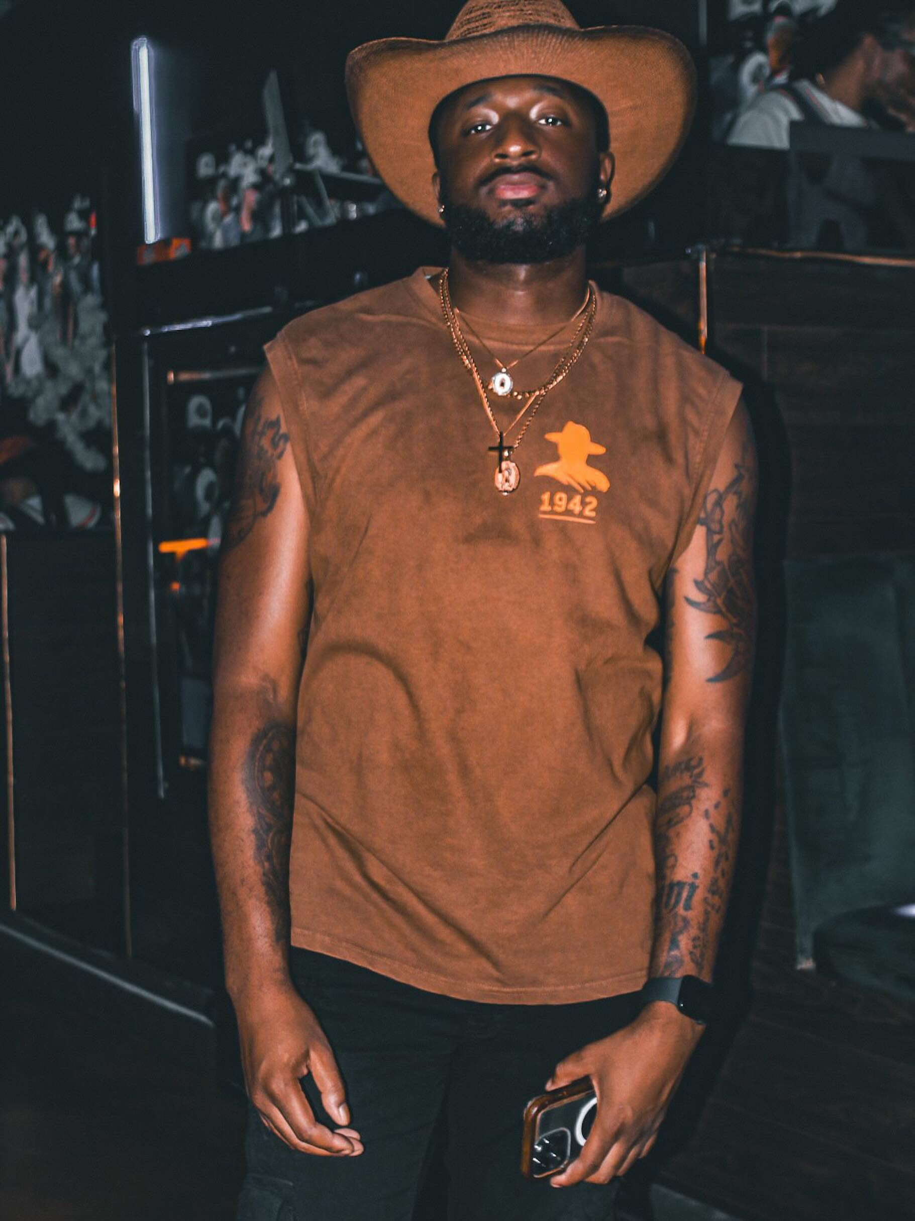 Man in a cowboy hat and brown shirt